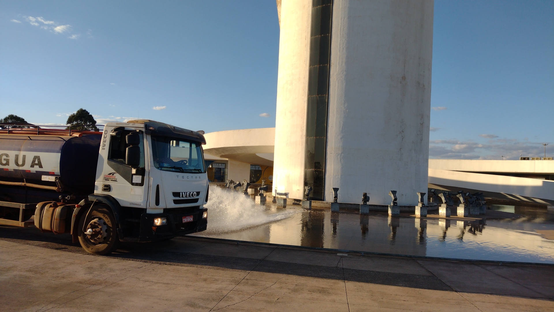 Caminhão pipa lavando espelho d'água em obra pública